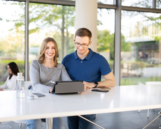 2 trainees looking on a laptop